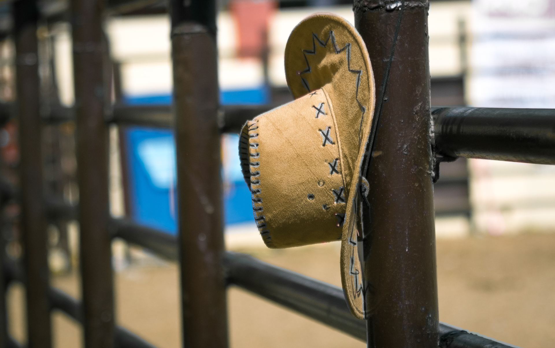 A cowboy hat hanging on the arena rails